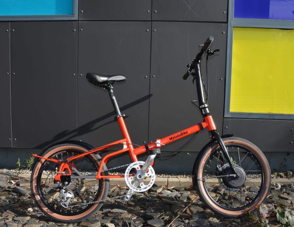 velo pliant electrique rouge le long d'une salle de sport
